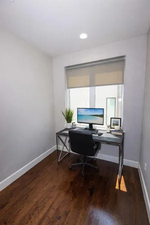 a view of a workspace with furniture and wooden floor