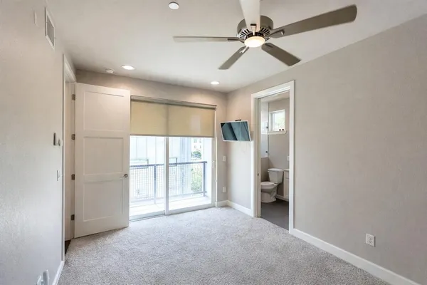 a view of empty room with a ceiling fan and window