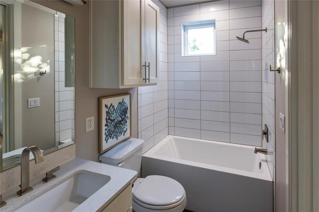 2016 North Fitzhugh Avenue, Unit 101 Dallas, TX 75204 - Photo 19 of 27 a bathroom with a sink a toilet a mirror a bathtub and shower