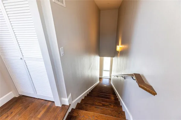 a view of a hallway with wooden floor and staircase