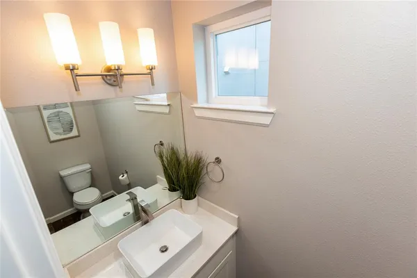 a view of bathroom with sink toilet and mirror