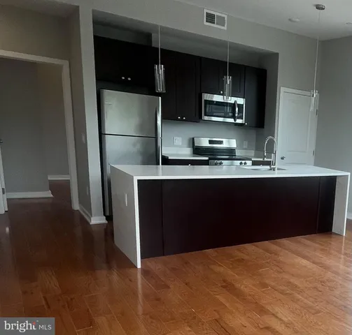 a kitchen with a sink a refrigerator and cabinets