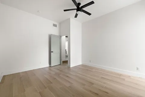 a view of room with hardwood floor and ceiling fan
