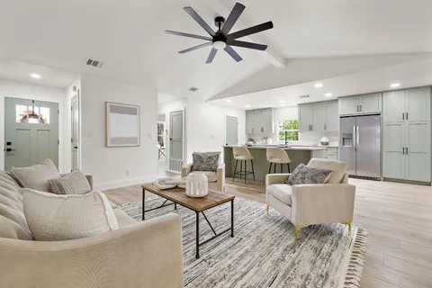 a living room with furniture and a wooden floor