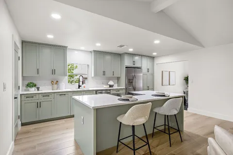 a kitchen with appliances a sink and cabinets