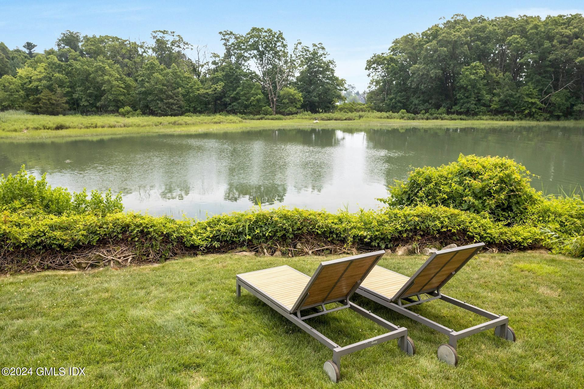 61 Roton Avenue Norwalk, CT 06853 - Photo 25 of 31 a view of a lake with a yard and a wooden fence