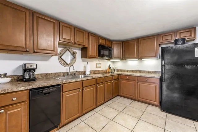 a kitchen with stainless steel appliances granite countertop a sink stove refrigerator and cabinets