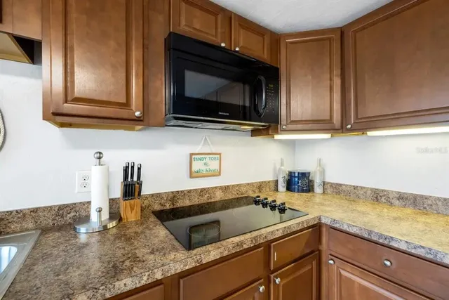 a kitchen with stainless steel appliances granite countertop a sink a microwave cabinets and a counter top space