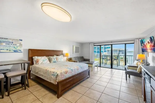 a bedroom with a bed and large windows