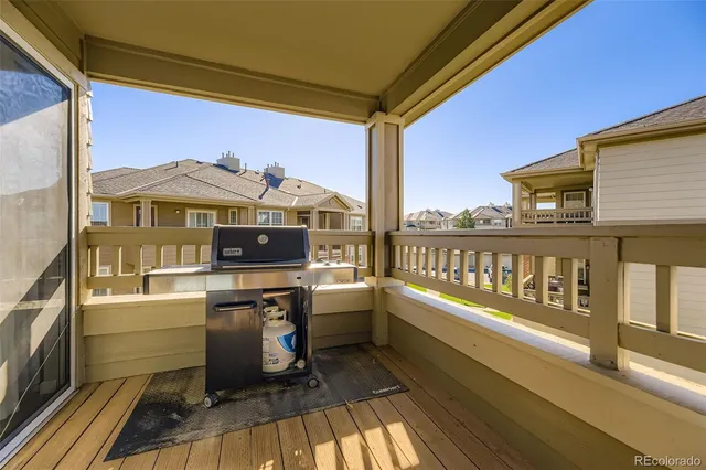 a view of a balcony with wooden chairs and city view