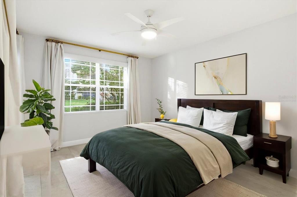 6536 Moorings Point Circle, Unit 101 Lakewood Ranch, FL 34202 - Photo 24 of 48 a bedroom with a bed and a potted plant