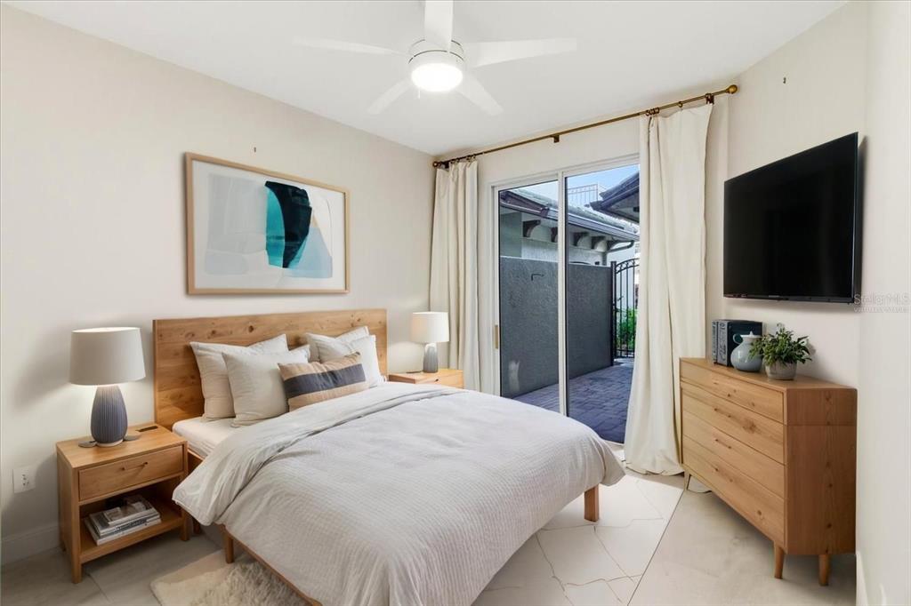 6536 Moorings Point Circle, Unit 101 Lakewood Ranch, FL 34202 - Photo 32 of 48 a bedroom with a bed and a flat tv screen on dresser