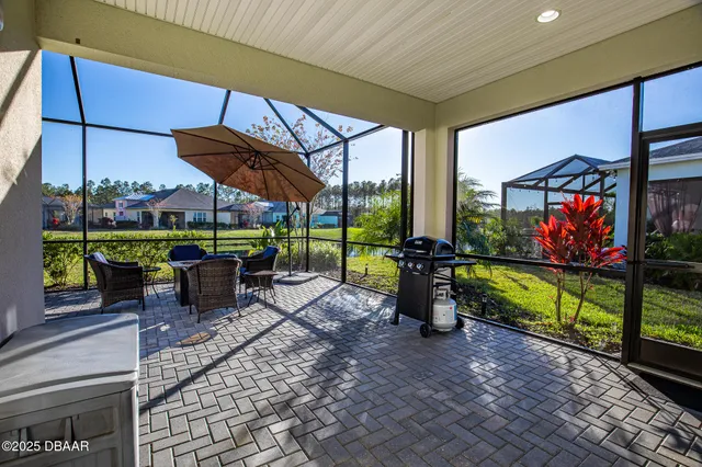 a view of a patio with a dining table and chairs under an umbrella