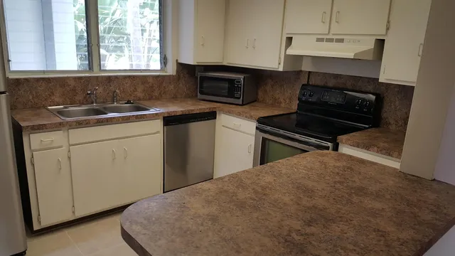 a kitchen with a refrigerator and a stove top oven