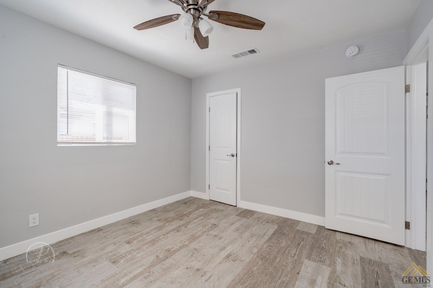 Undisclosed Address Bakersfield, CA 93305 - Photo 17 of 28 a view of empty room with wooden floor and fan