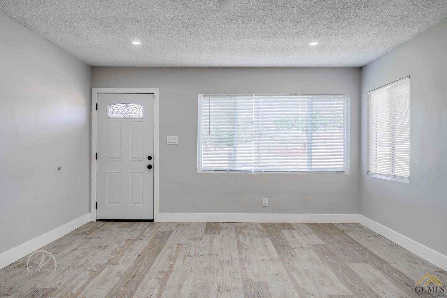 Undisclosed Address Bakersfield, CA 93305 - Photo 3 of 28 an empty room with wooden floor and windows