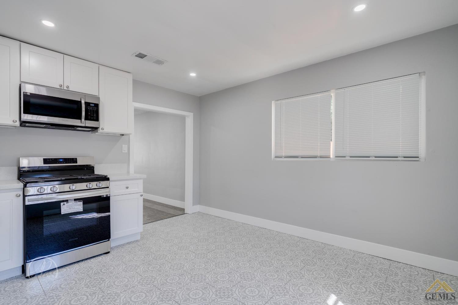 Undisclosed Address Bakersfield, CA 93305 - Photo 7 of 28 a kitchen with stainless steel appliances granite countertop a stove and a microwave