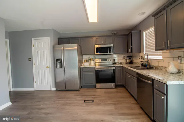 a kitchen with stainless steel appliances granite countertop a refrigerator stove top oven a sink and dishwasher