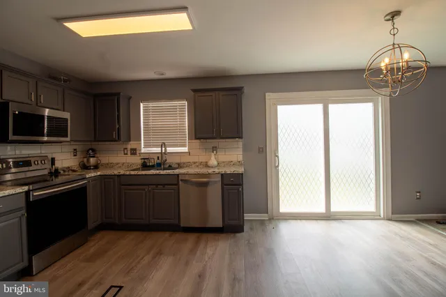 a kitchen with granite countertop stainless steel appliances and wooden cabinets