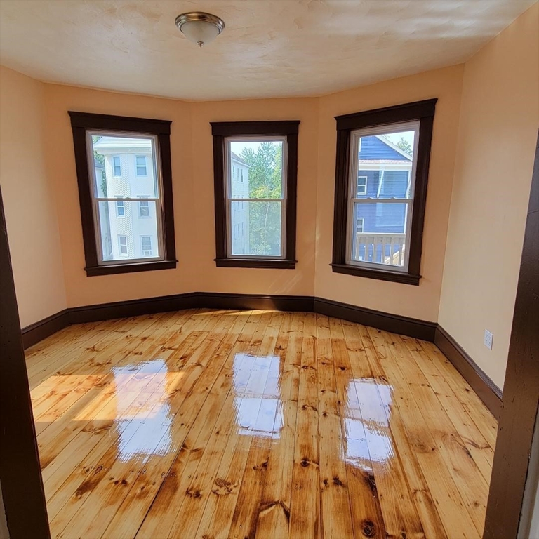 111 Rodney Street, Unit 1 Worcester, MA 01605 - Photo 2 of 9 a view of an empty room with window and wooden floor