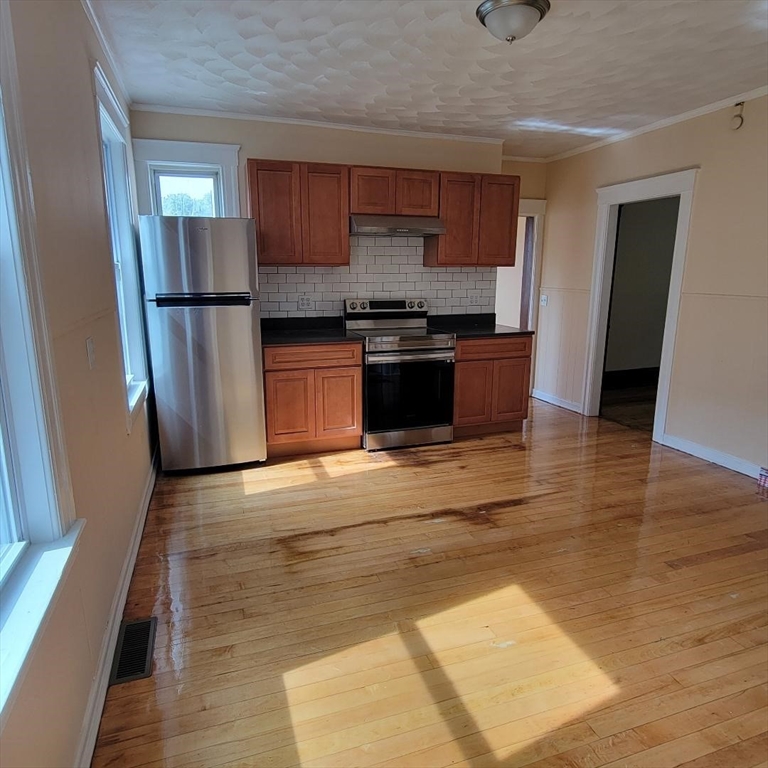 111 Rodney Street, Unit 1 Worcester, MA 01605 - Photo 6 of 9 a kitchen with stainless steel appliances granite countertop a refrigerator and a stove