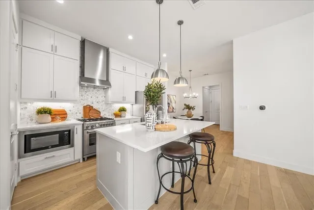 a kitchen with stainless steel appliances kitchen island a table and chairs in it