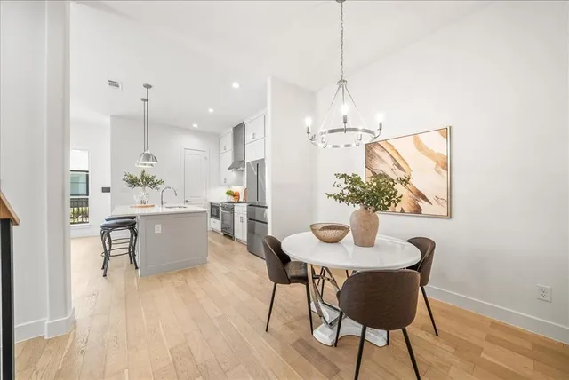 a view of a dining room with furniture wooden floor and chandelier