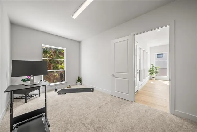 a view of a workspace with furniture and a window