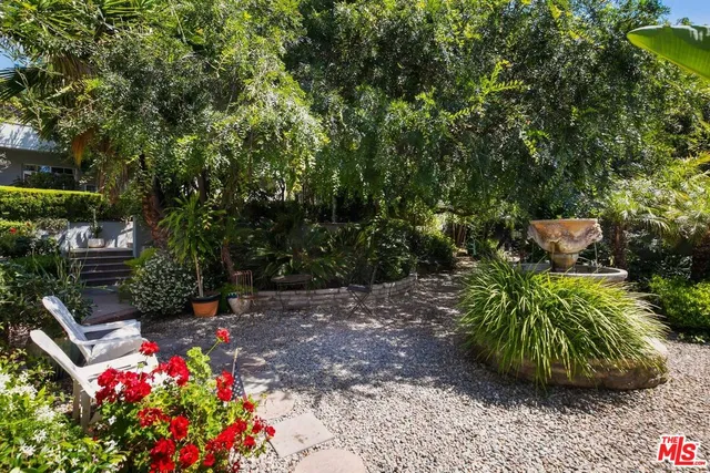 a flower garden with lots of plants and trees