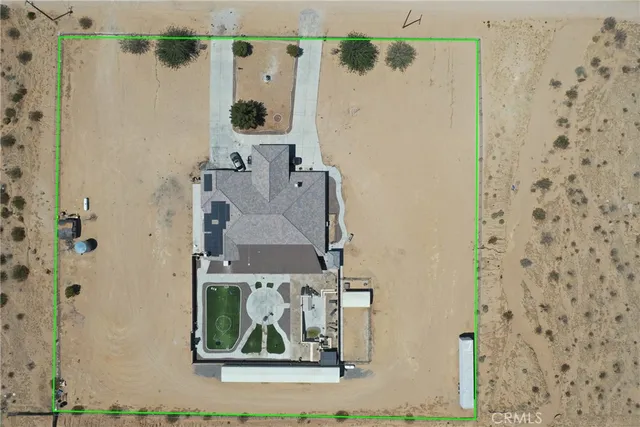 an aerial view of a house with a yard and ocean view