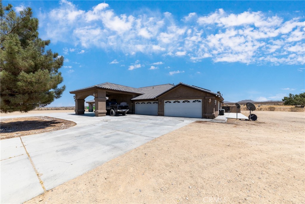 24625 Ledbury Road Oro Grande, CA 92368 - Photo 22 of 51 a front view of a house with a yard and garage