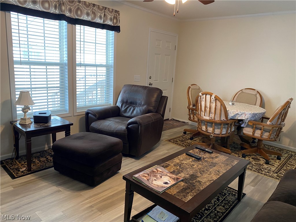 2700 Brookpark Road, Unit 626 Cleveland, OH 44134 - Photo 14 of 32 Living room with a healthy amount of sunlight, light hardwood / wood-style floors, ceiling fan, and crown molding