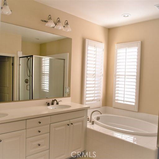56 Twin Gables Irvine, CA 92620 - Photo 26 of 32 a bathroom with a double vanity sink bathtub and next to a window