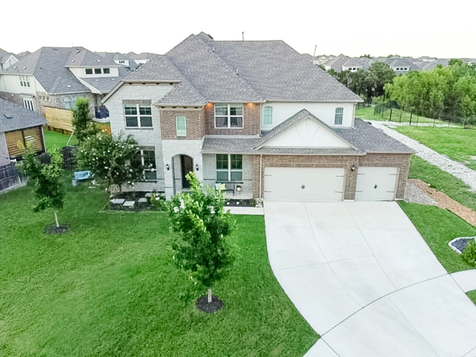 a aerial view of a house next to a big yard and large trees