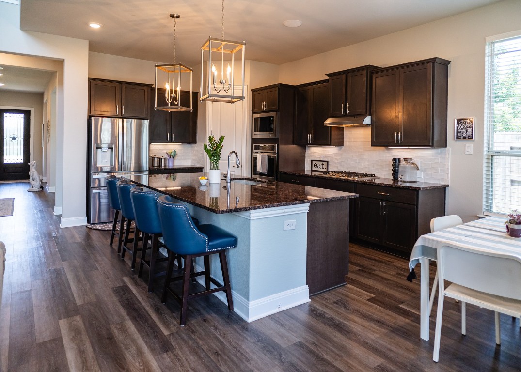 2616 Pine Branch Road Leander, TX 78641 - Photo 5 of 37 a kitchen with granite countertop a sink stove and refrigerator