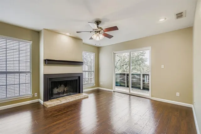 a view of a livingroom with a fireplace wooden floor and windows