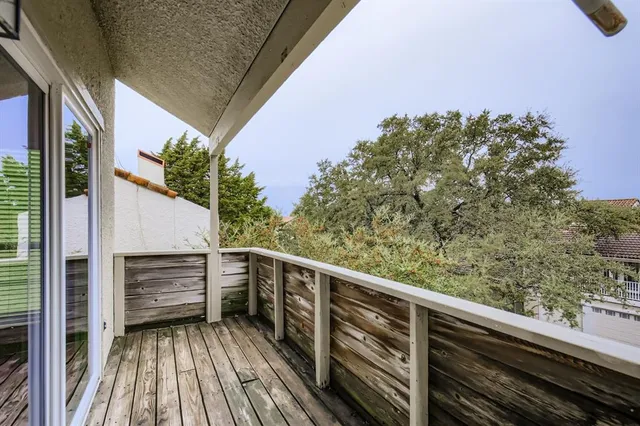 a view of balcony with wooden floor and fence