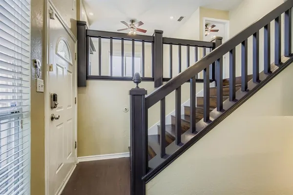 a view of staircase with lots of frames on wall and a window