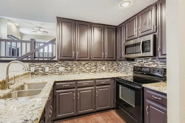 a kitchen with granite countertop cabinets stainless steel appliances and a sink