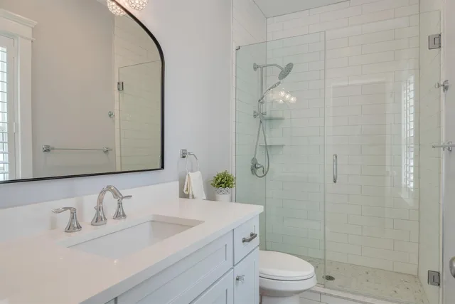 a bathroom with a granite countertop sink a toilet and a mirror