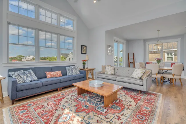 a living room with furniture a rug and a table