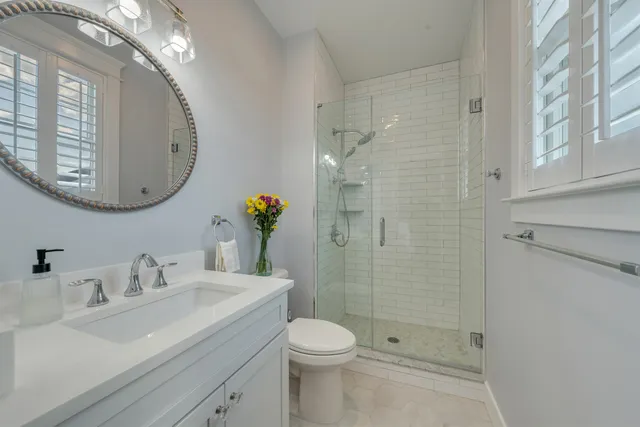 a bathroom with a sink a toilet and shower