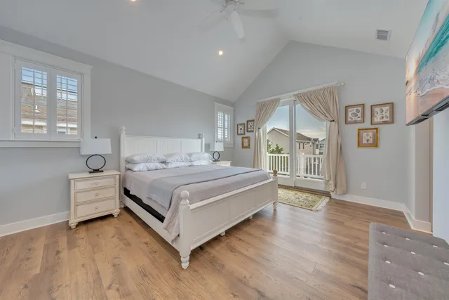 a bedroom with a large bed and a wooden floor