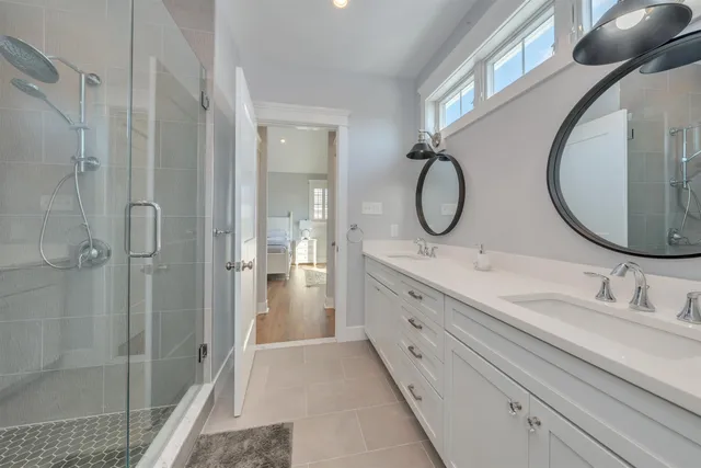 a bathroom with a double vanity sink mirror double and shower