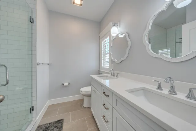 a bathroom with a double vanity sink mirror and toilet