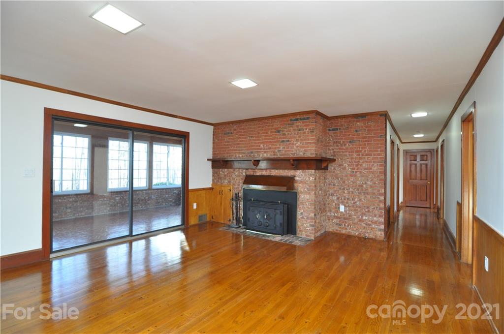 1011 Redland Road Landrum, SC 29356 - Photo 22 of 45 an empty room with wooden floor fireplace and windows