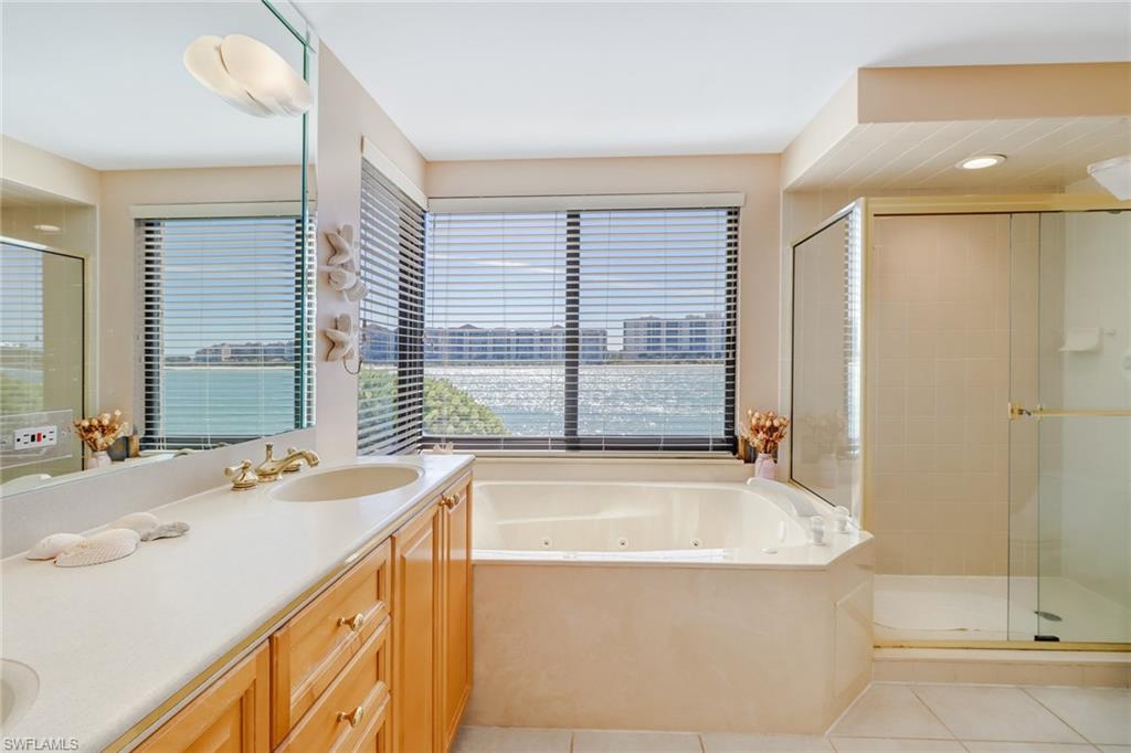 400 La Peninsula Boulevard, Unit 404 Naples, FL 34113 - Photo 12 of 19 a bathroom with a tub sink and mirror