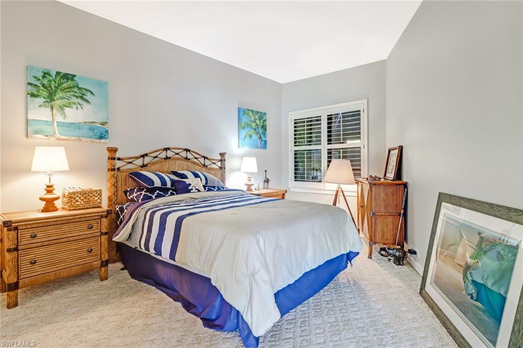 400 La Peninsula Boulevard, Unit 404 Naples, FL 34113 - Photo 14 of 19 a bedroom with a bed and wooden floor