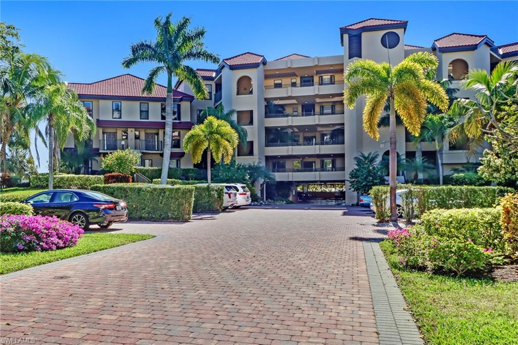 400 La Peninsula Boulevard, Unit 404 Naples, FL 34113 - Photo 19 of 19 a front view of multi story residential apartment building with yard and outdoor seating
