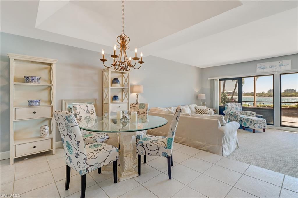 400 La Peninsula Boulevard, Unit 404 Naples, FL 34113 - Photo 6 of 19 a view of a dining room with furniture and wooden floor